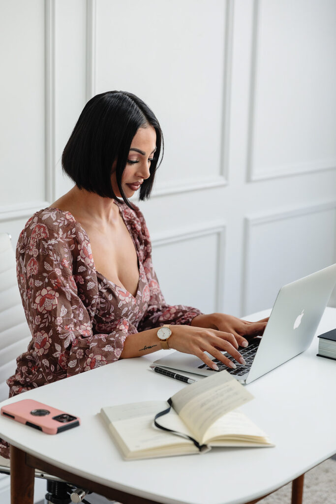 branding session for a love coach sitting at a desk using a laptop