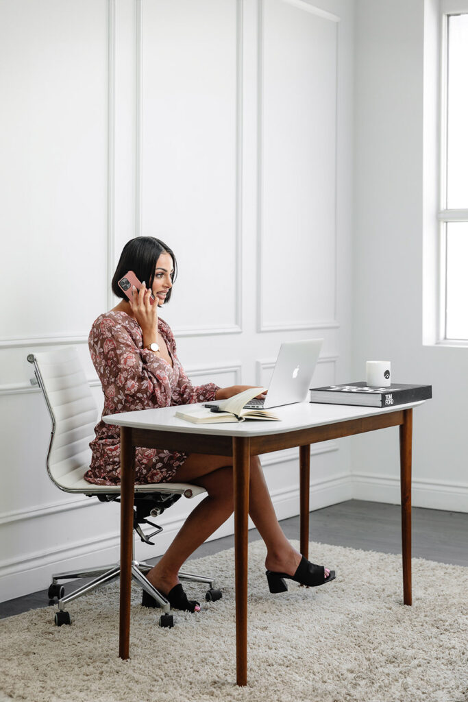 branding session for a woman sitting at a desk talking on a cell phone