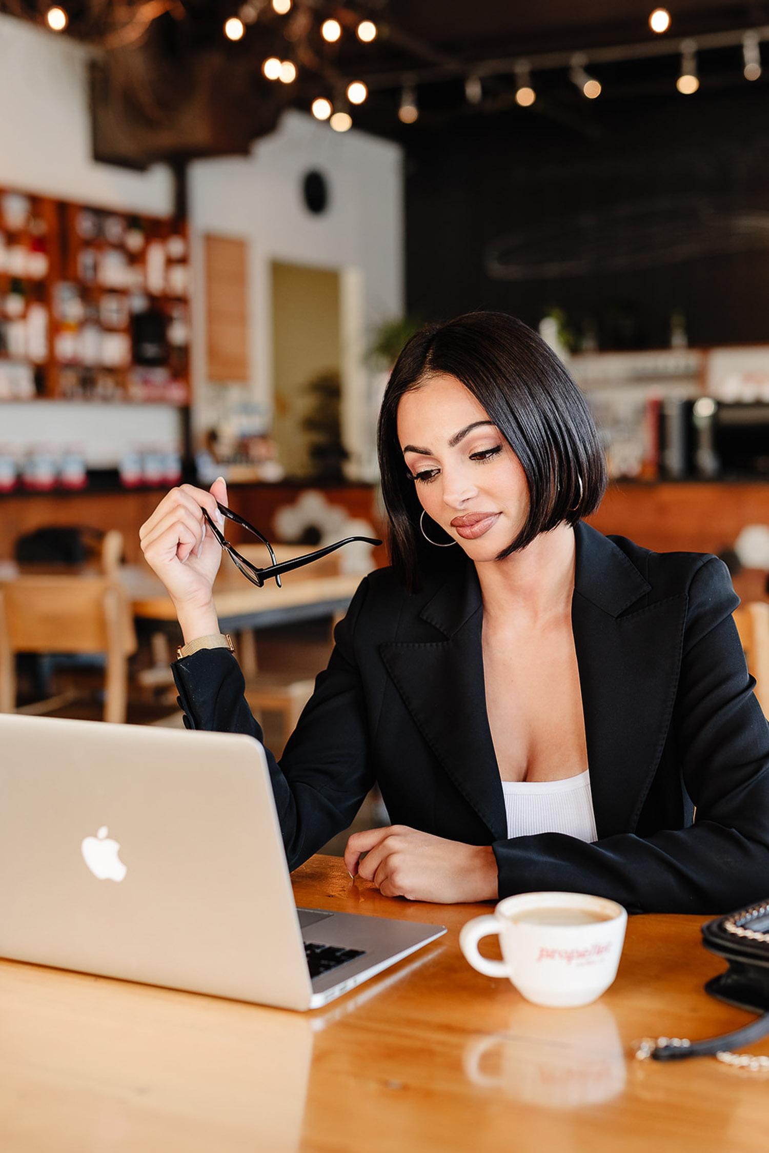 branding session for a matchmaker sitting at a table with a laptop and a cup of coffee